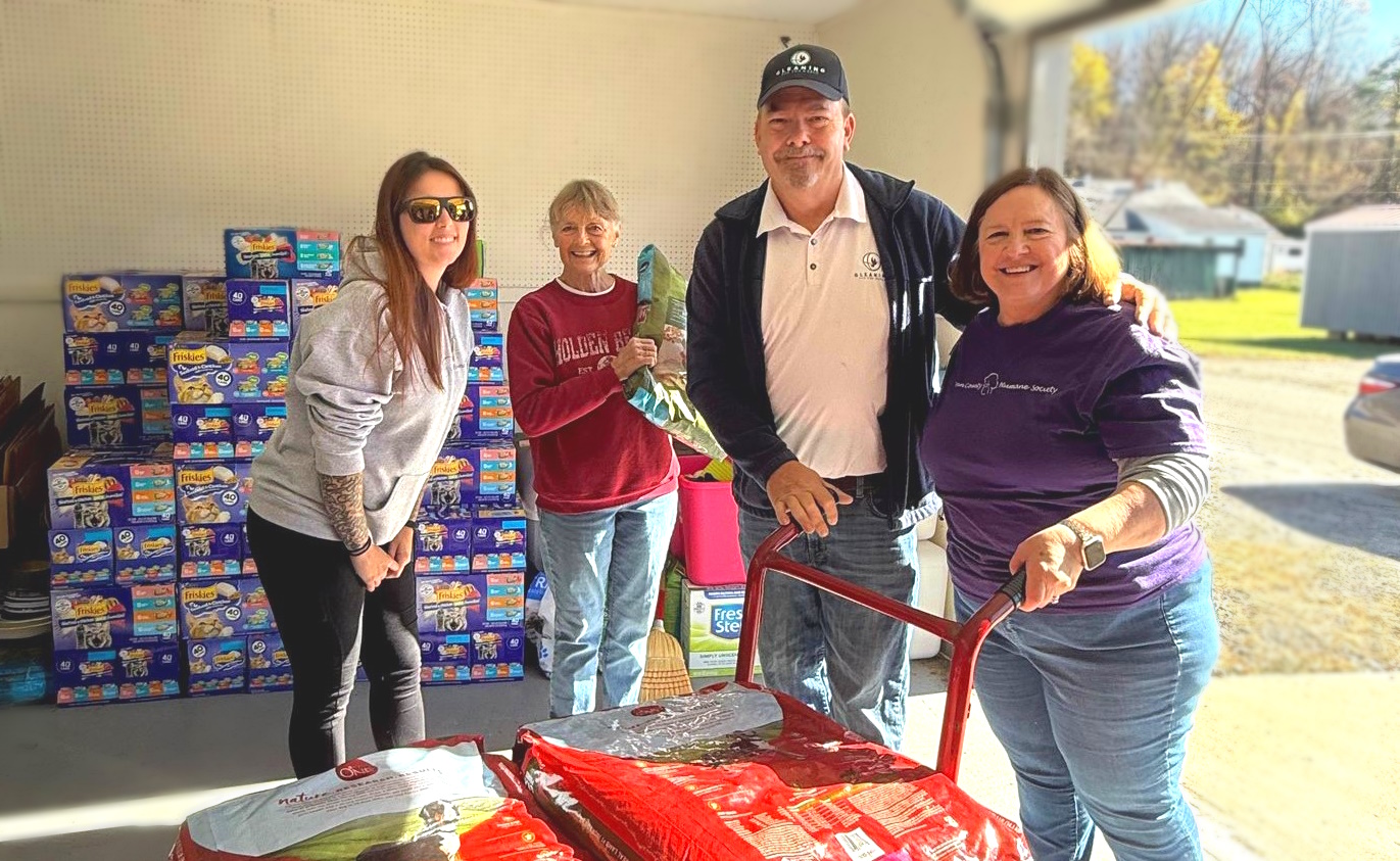 Four TCHS volunteers with donated bags of pet food