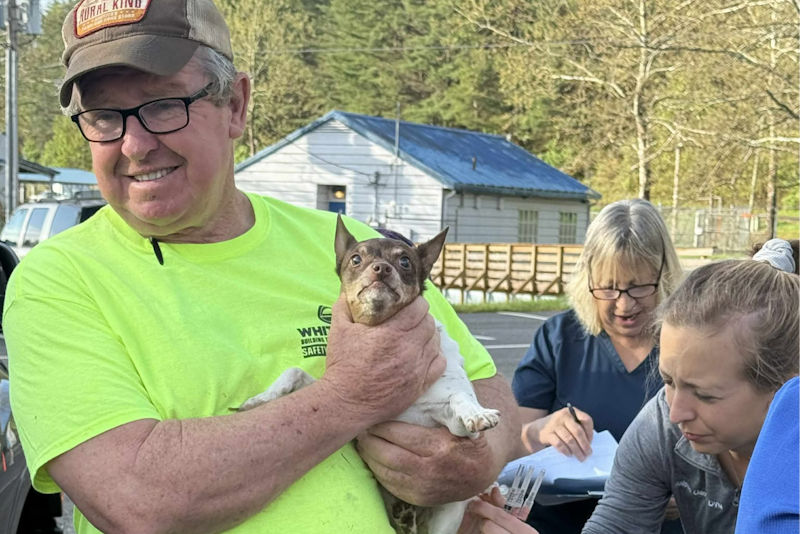 man holding small dog in his arms
