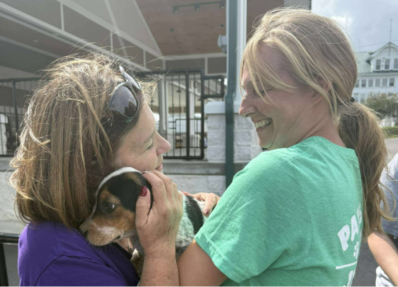 two women holding a puppy